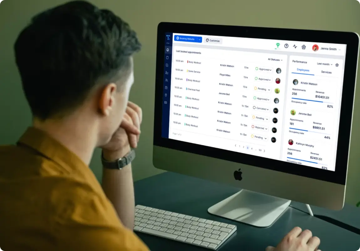 A man sitting in front of a computer, looking at the list of booked appointments in the Trafft booking app