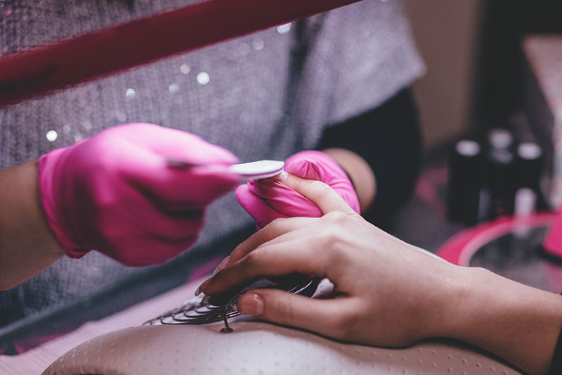 a nail artist working on customer's nails 