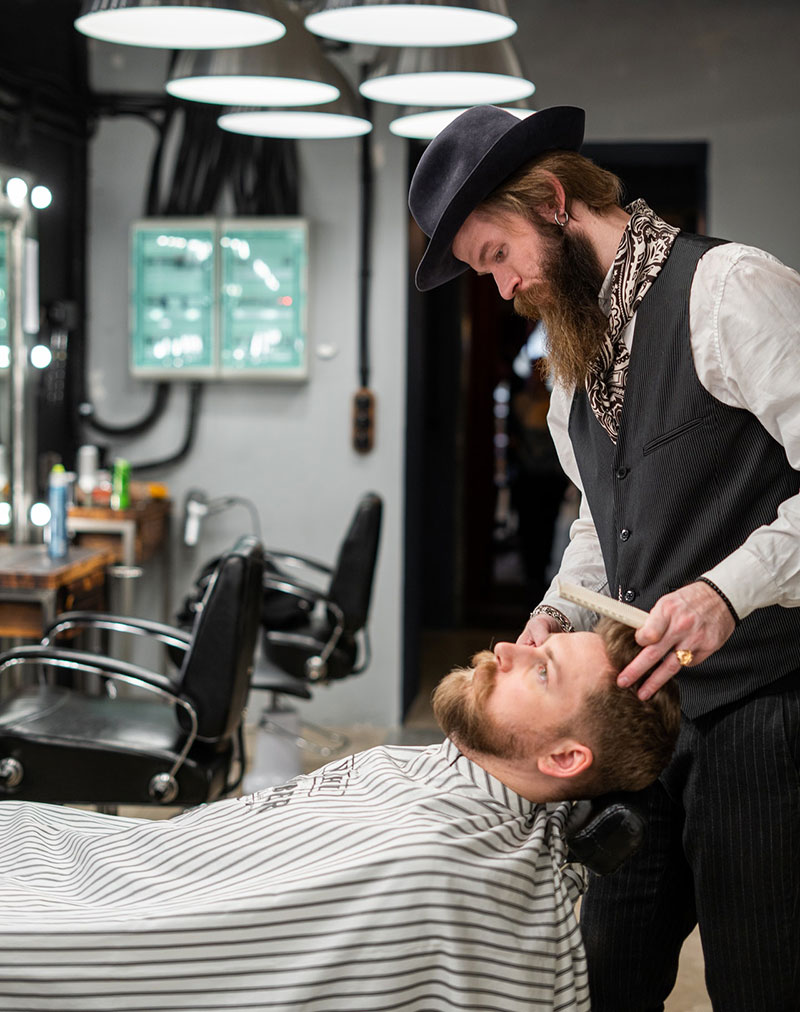 a barber giving a customer a beard trim